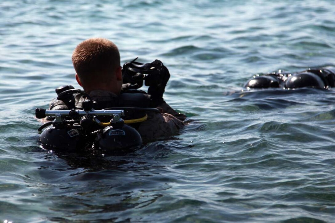 A Marine with Reconnaissance Platoon, Battalion Landing Team 3/5, 15th Marine Expeditionary Unit, puts on his equipment during a scuba training exercise, Feb. 24. The 15th MEU is deployed as part of the Peleliu Amphibious Ready Group as a U.S. Central Command theater reserve force, providing support for maritime security operations and theater security cooperation efforts in the U.S. 5th Fleet area of responsibility. (U.S. Marine Corps photo by Cpl. John Robbart III/Released)