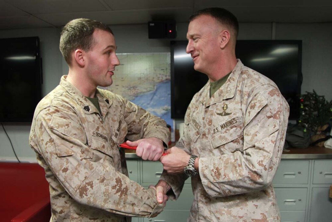 Sergeant Zachary T. Schearer, career planner, Command Element, 15th Marine Expeditionary Unit, shakes hands with Col. Scott D. Campbell, his commanding officer, and receives the citation for his Navy and Marine Corps Achievement Medal aboard USS Peleliu, March 6. The 15th MEU is deployed as part of the Peleliu Amphibious Ready Group as a U.S. Central Command theater reserve force, providing support for maritime security operations and theater security cooperation efforts in the U.S. 5th Fleet area of responsibility. Schearer, 22, is from Blandon, Pa. (U.S. Marine Corps photo by Cpl. John Robbart III)