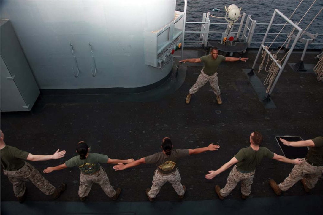 Marines with the 15th Marine Expeditionary Unit participate in a physical training session led by Sgt. Maj. John W. Scott, the unit's sergeant major, as part of Corporals' Course on USS Peleliu, March 8. The 15th MEU is deployed as part of the Peleliu Amphibious Ready Group as a U.S. Central Command theater reserve force, providing support for maritime security operations and theater security cooperation efforts in the U.S. 5th Fleet area of responsibility. (U.S. Marine Corps photo by Cpl. John Robbart III)