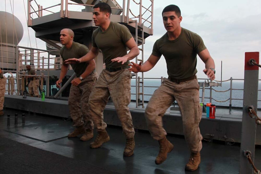 Marines with the 15th Marine Expeditionary Unit participate in a physical training session led by Sgt. Maj. John W. Scott, the unit's sergeant major, as part of Corporals' Course on USS Peleliu, March 8. The 15th MEU is deployed as part of the Peleliu Amphibious Ready Group as a U.S. Central Command theater reserve force, providing support for maritime security operations and theater security cooperation efforts in the U.S. 5th Fleet area of responsibility. (U.S. Marine Corps photo by Cpl. John Robbart III)