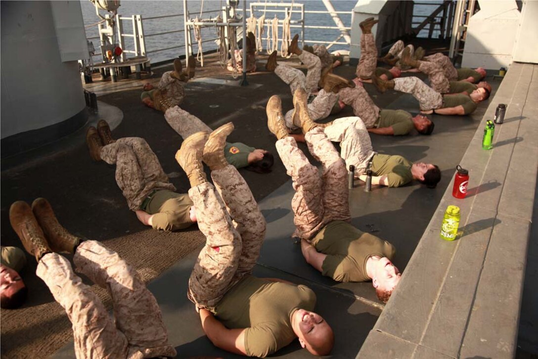 Marines with the 15th Marine Expeditionary Unit participate in a physical training session led by Sgt. Maj. John W. Scott, the unit's sergeant major, as part of Corporals' Course on USS Peleliu, March 8. The 15th MEU is deployed as part of the Peleliu Amphibious Ready Group as a U.S. Central Command theater reserve force, providing support for maritime security operations and theater security cooperation efforts in the U.S. 5th Fleet area of responsibility. (U.S. Marine Corps photo by Cpl. John Robbart III)