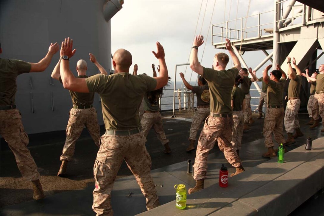 Marines with the 15th Marine Expeditionary Unit participate in a physical training session led by Sgt. Maj. John W. Scott, the unit's sergeant major, as part of Corporals' Course on USS Peleliu, March 8. The 15th MEU is deployed as part of the Peleliu Amphibious Ready Group as a U.S. Central Command theater reserve force, providing support for maritime security operations and theater security cooperation efforts in the U.S. 5th Fleet area of responsibility. (U.S. Marine Corps photo by Cpl. John Robbart III)