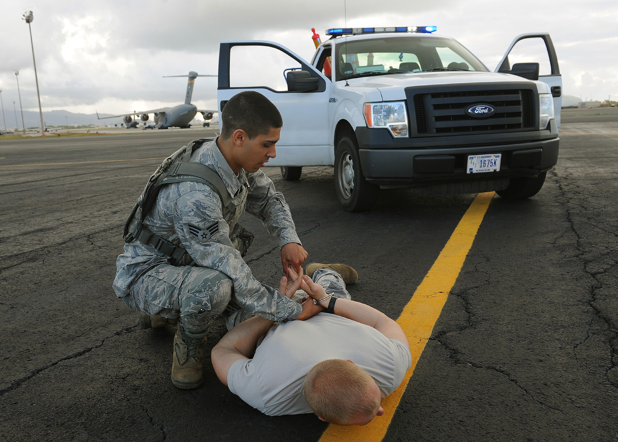 Senior Airman Brendan Hayes, 647th Security Forces Squadron fire team lead, apprehends a simulated trespasser on the flightline during an Operational Readiness Exercise at Joint Base Pearl Harbor-Hickam, Hawaii, March 9, 2013.  Keeping our aircraft and flightline safe is a top priority of our Security Forces Defenders. (U.S. Air Force photo/Tech. Sgt. Jerome S. Tayborn) 