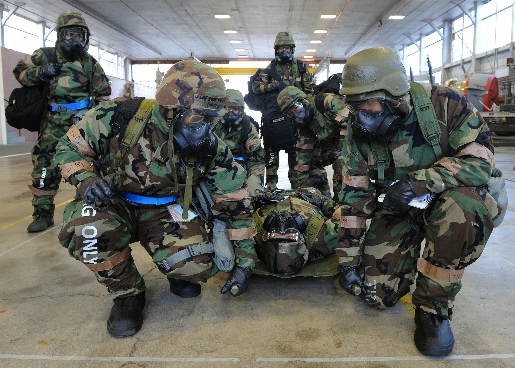 Members from the 15th Aircraft Maintenance Squadron and the 154th Hawaii Air National Guard Aircraft Maintenance Squadron prepare to perform a four-man carry using a litter on a simulated wounded Airman at Hangar 17 during an Operational Readiness Exercise at Joint Base Pearl Harbor-Hickam, Hawaii, March 9, 2013. This exercise demonstrates the effective use of Total Force Integration by including both 15th Wing and 154th HIANG Airmen working side-by-side to accomplish the mission.  (U.S. Air Force photo/Tech. Sgt. Jerome S. Tayborn)