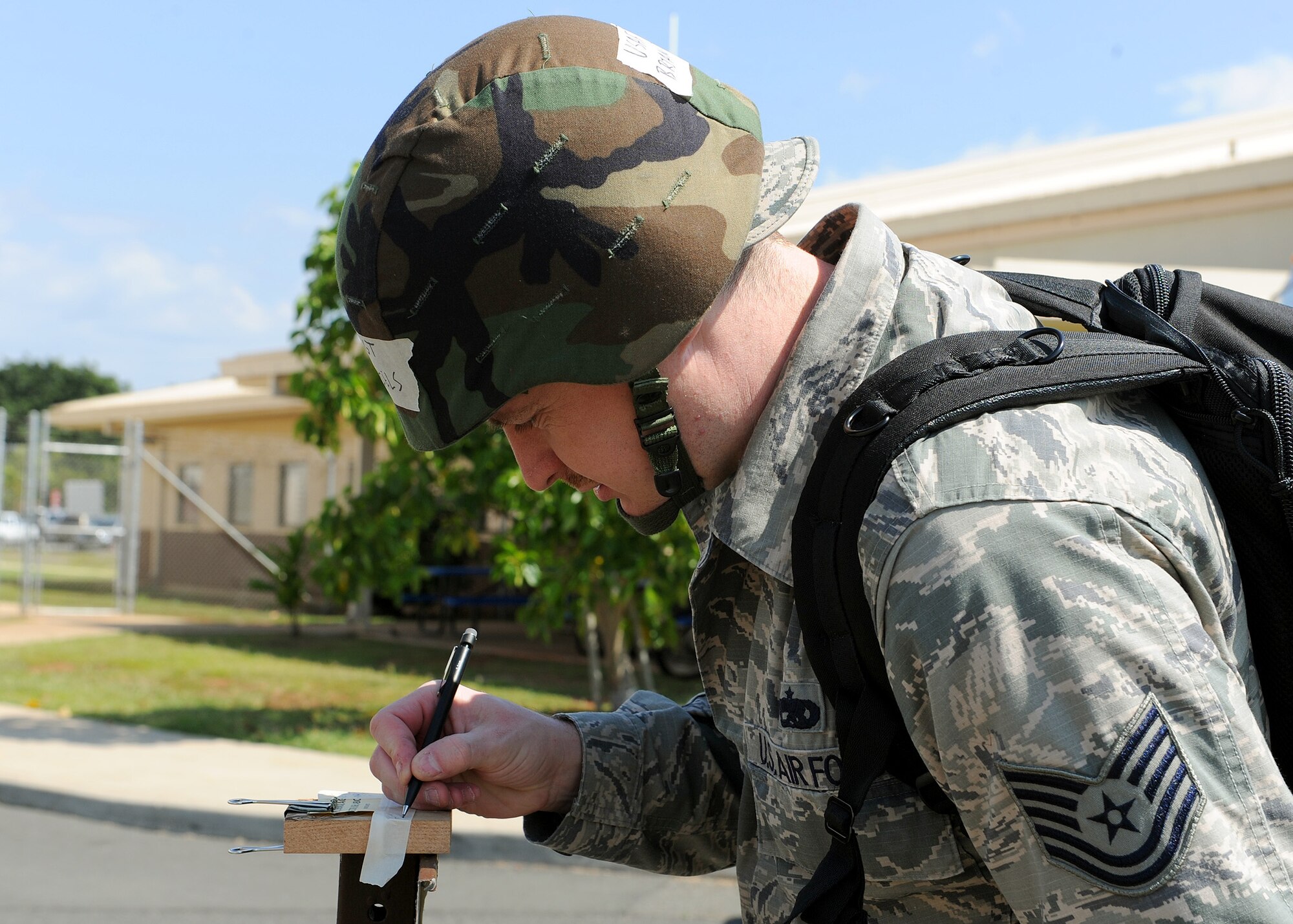 Tech. Sgt. Brian Daniels, 15th Maintenance Group guidance and control lead technician, marks and dates M8 paper while conducting a Post-Attack Reconnaissance check around the perimeter of the C-17 Aircraft Maintenance Squadron during an Operational Readiness Exercise, Joint Base Pearl Harbor-Hickam, Hawaii, March 8, 2013.  The ORE conducts training and evaluates a unit’s ability to operate and launch missions in a simulated chemical combat environment.  (U.S. Air Force photo/Tech. Sgt. Jerome S. Tayborn)