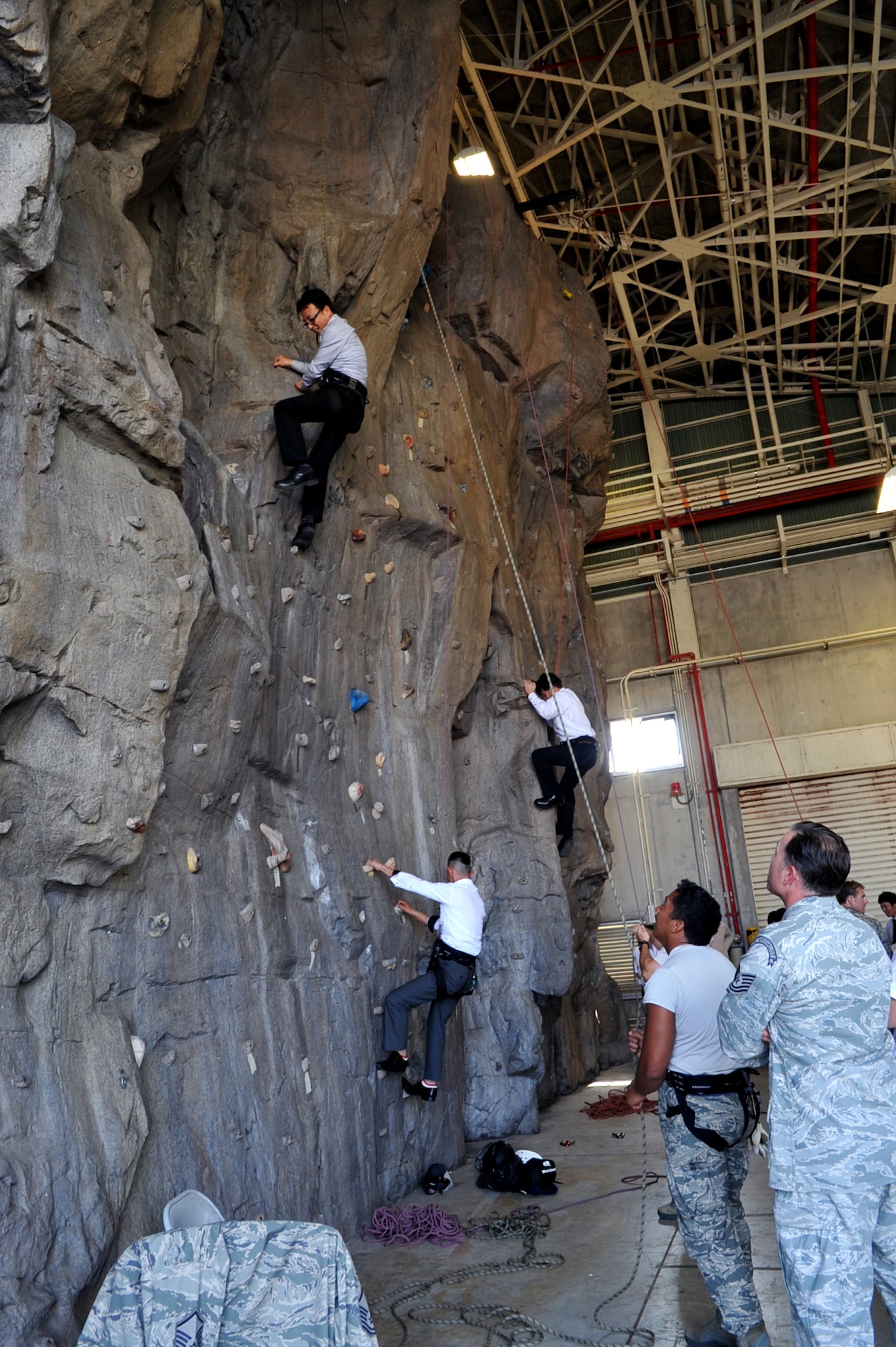 Japan Youth Chambers of Commerce members climb a rock wall, called "high angle rescue simulator training,” during a national convention on Kadena Air Base, Japan, March 8, 2013. Only 123 people out of 5,000 selected members were able to visit Kadena for the base tour. (U.S. Air Force photo/Naoto Anazawa)