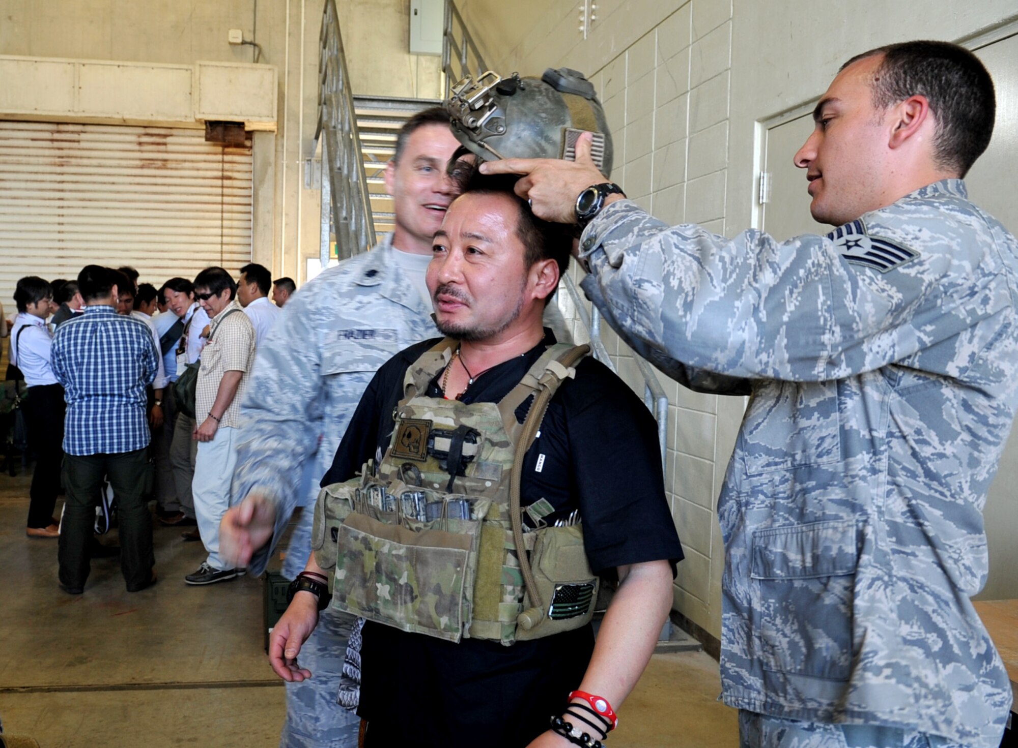 U.S. Air Force Staff Sgt. Andrew Benigno, 31st Rescue Squadron cyber transport systems craftman, helps a Japan Youth Chambers of Commerce member with putting gear on during a national convention on Kadena Air Base, Japan, March 8, 2013. The purpose of the national convention is to boost the economy of the prefecture holding the convention, to learn about special/local products of the prefecture and to interact with participants from all over Japan to network. (U.S. Air Force photo/Naoto Anazawa)