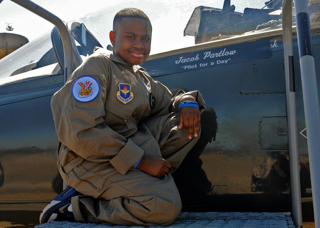 Jacon Partlow, Pilot for a Day participant poses next to his name on a T-38 Talon on March 8 at Columbus Air Force Base. Partlow, who was diagnosed with acute lymphoblastic leukemia back in 2009, spent the day experiencing life as a pilot in the Air Force. (U.S. Air Force photo/Melissa Doublin)