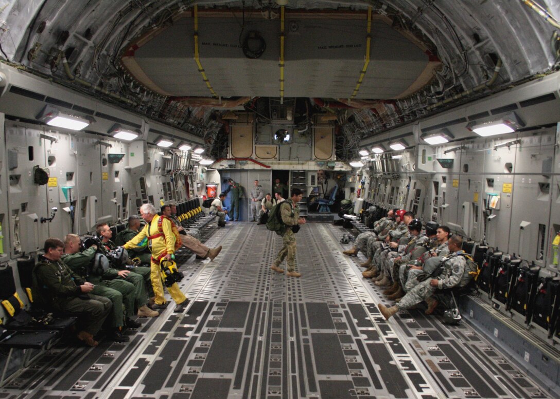 Tom Sanders (far left) talks with Special Operations Command, Pacific members in a C-17 Globemaster III Feb. 26, 2013, near Joint Base Pearl Harbor Hickam-Hawaii. Sanders, who has been skydiving for more than 35 years, was on hand to film a freefall jump as part of an upcoming scene for television show “Hawaii Five-0,” in which two SOCPAC jumpers will serve as stunt doubles for the show’s actors. Though it was Sanders’ first jump from a C-17, he’s had the opportunity to jump with high profile clients such as the former Chairman of the Joint Chiefs of Staff Gen. Hugh Shelton and former U.S. President George Bush. This episode will air Monday, April 15 on CBS at 10PM Eastern time. Sanders is a veteran freefall cameraman and skydiver cinematographer. (Photo by James Menne)