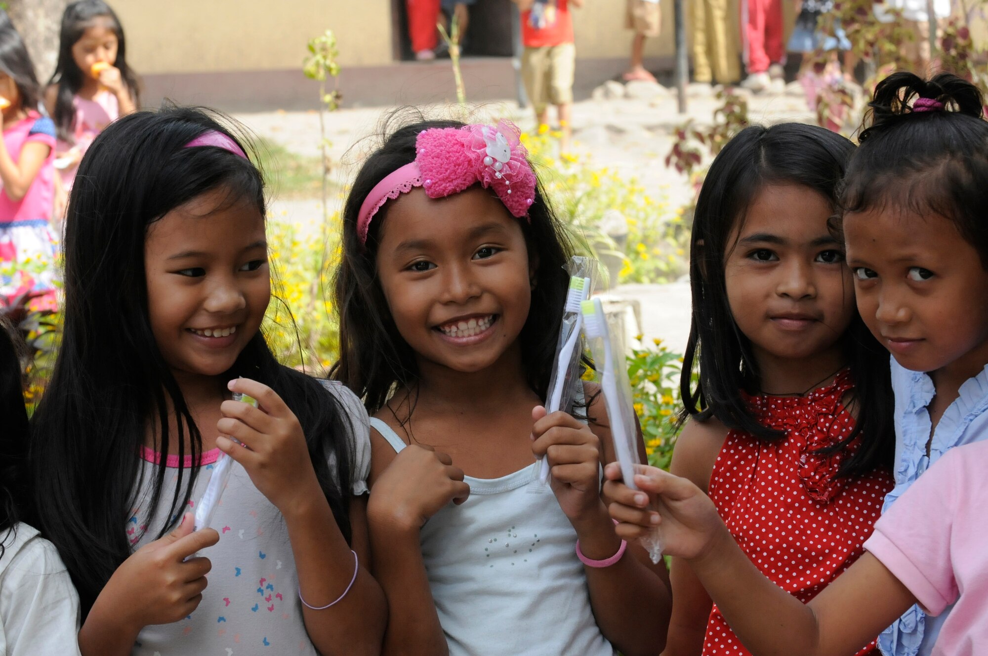 Elementary students show off the toothbrushes given to them during an Operation Pacific Angel-Philippines subject-matter expert exchange held in Dumaguete, Philippines, March 7, 2013. The dental technicians team visited the school to teach dental hygiene. Operation Pacific Angel is a joint and combined humanitarian assistance exercise held in various countries several times a year and includes medical, dental, optometry, engineering programs and various subject-matter expert exchanges. (U.S. Air Force photo/Senior Master Sgt. J.C. Woodring)