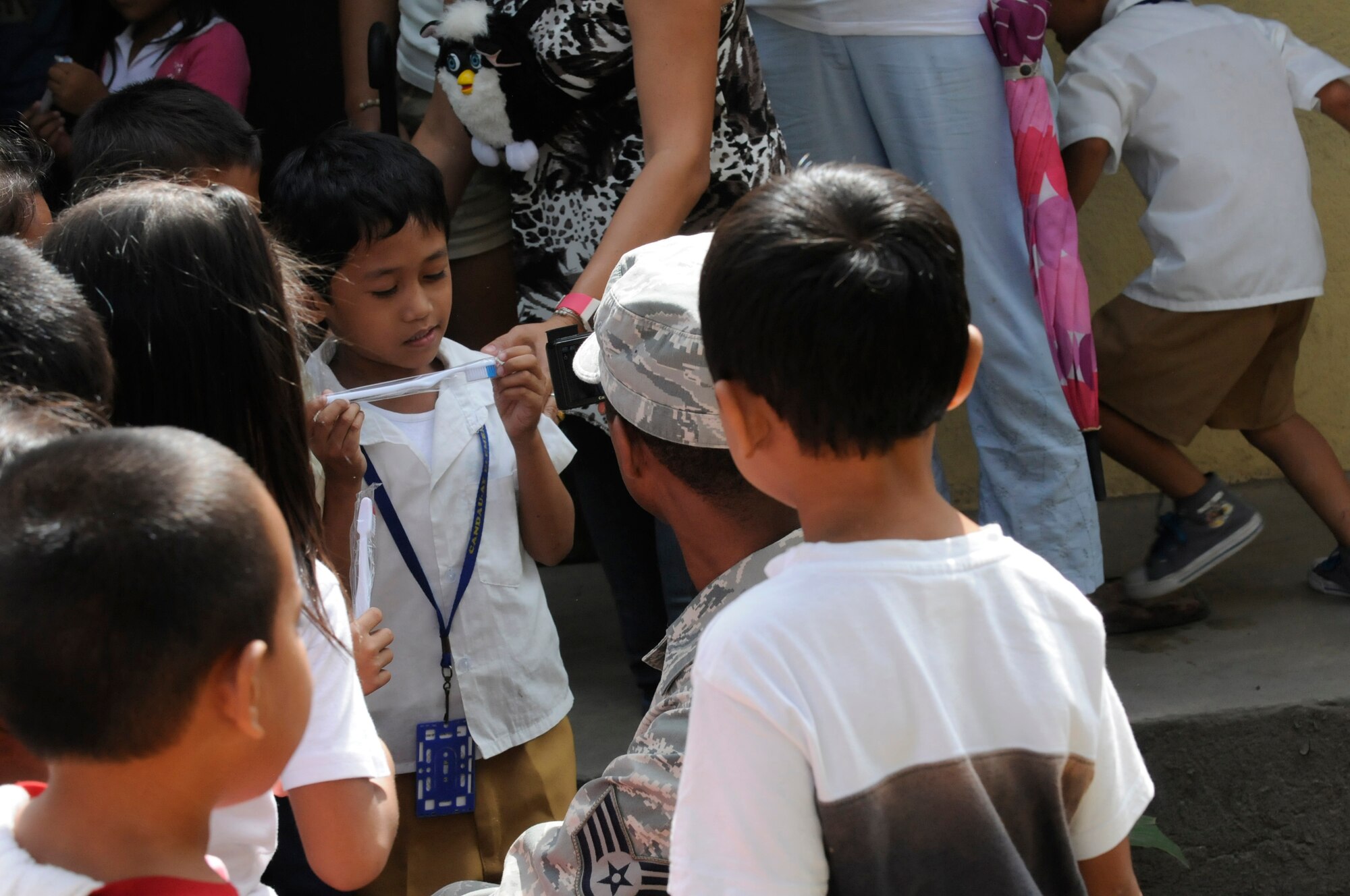 Elementary students show their toothbrushes to U.S. Air Force Staff Sgt. Richard Glass during an Operation Pacific Angel-Philippines subject-matter expert exchange held in Dumaguete, Philippines, March 7, 2013. Glass is a dental technician from Misawa Air Base, Japan, and was part of a team who visited the school to teach dental hygiene. Operation Pacific Angel is a joint and combined humanitarian assistance exercise held in various countries several times a year and includes medical, dental, optometry, engineering programs and various subject-matter expert exchanges. (U.S. Air Force photo/Senior Master Sgt. J.C. Woodring) 