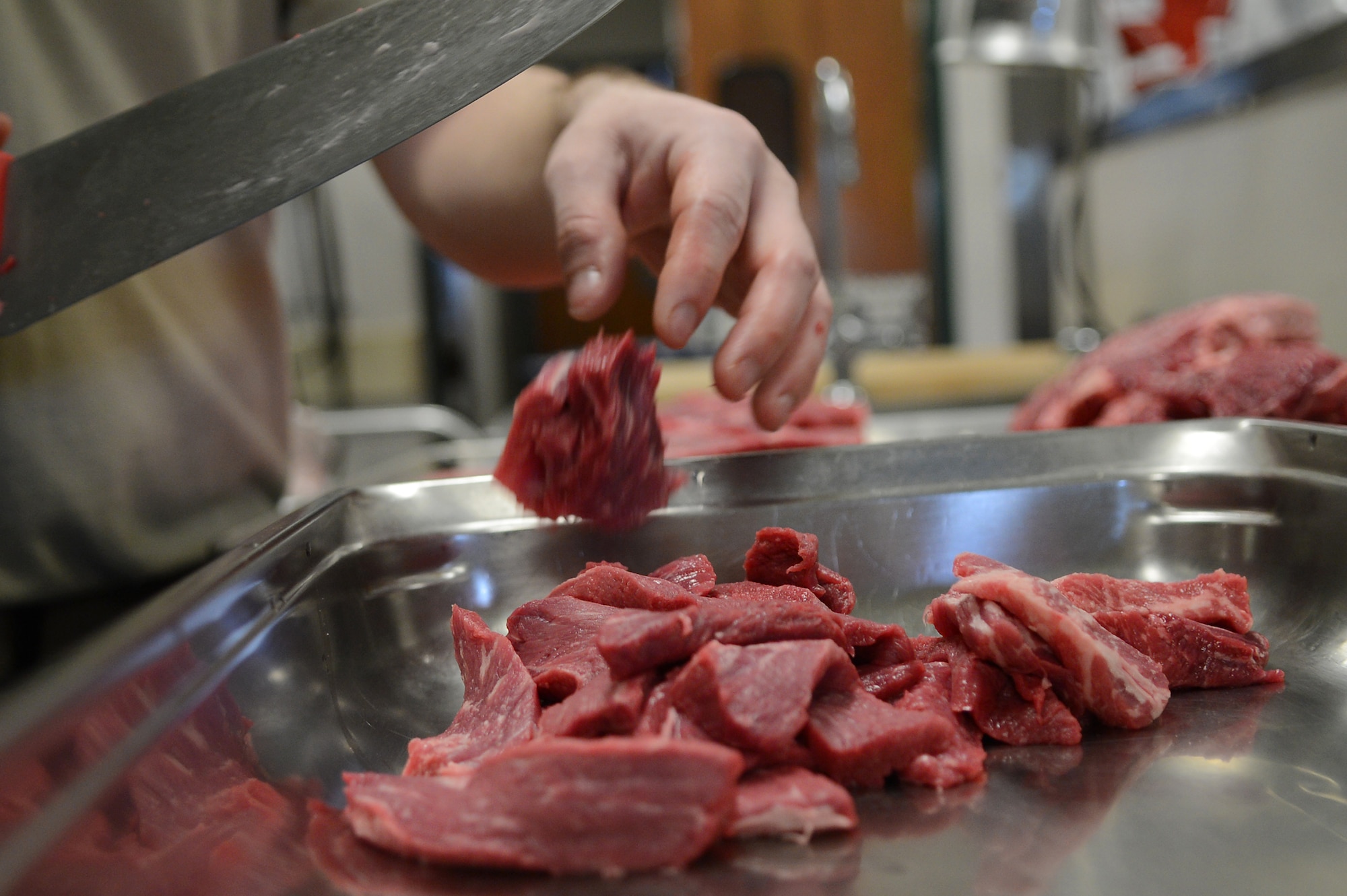 U.S. Air Force Senior Airman Matthew Davenport, 20th Force Support Squadron food service specialist, cuts beef for dinner at the Chief Emerson Dining Facility, Shaw Air Force Base, S.C., March 6, 2013. Public health inspects the facility at least once a quarter. Some are planned inspections and others without notice.  (U.S. Air Force photo by Airman 1st Class Nicole Sikorski/Released)