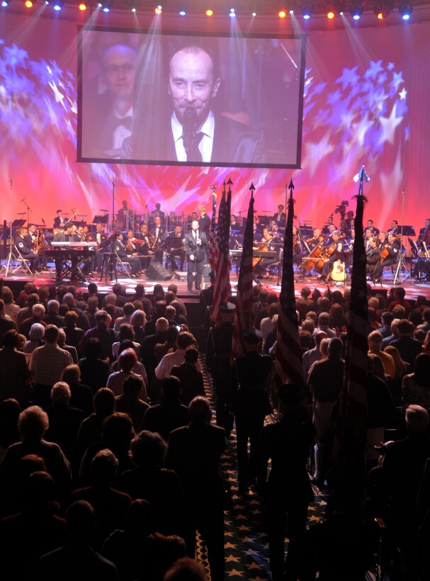 Singing his hit "God Bless the USA," Grammy Award winner Lee Greenwood, along with a U.S. Air Force Honor Guard flag processional, bring the Guest Artist Series performance at DAR Constitution Hall in Washington, D.C. to a close March 10. Greenwood was the final guest artist to be featured in the 2013 Air Force Band's Guest Artist Series. (U.S. Air Force photo/Senior Airman Lindsey A. Porter)