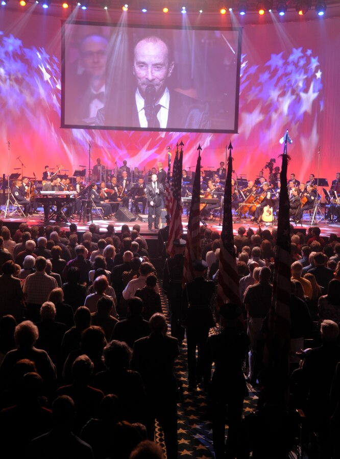 Singing his hit "God Bless the USA," Grammy Award winner Lee Greenwood, along with a U.S. Air Force Honor Guard flag processional, bring the Guest Artist Series performance at DAR Constitution Hall in Washington, D.C. to a close March 10. Greenwood was the final guest artist to be featured in the 2013 Air Force Band's Guest Artist Series. (U.S. Air Force photo/Senior Airman Lindsey A. Porter)
