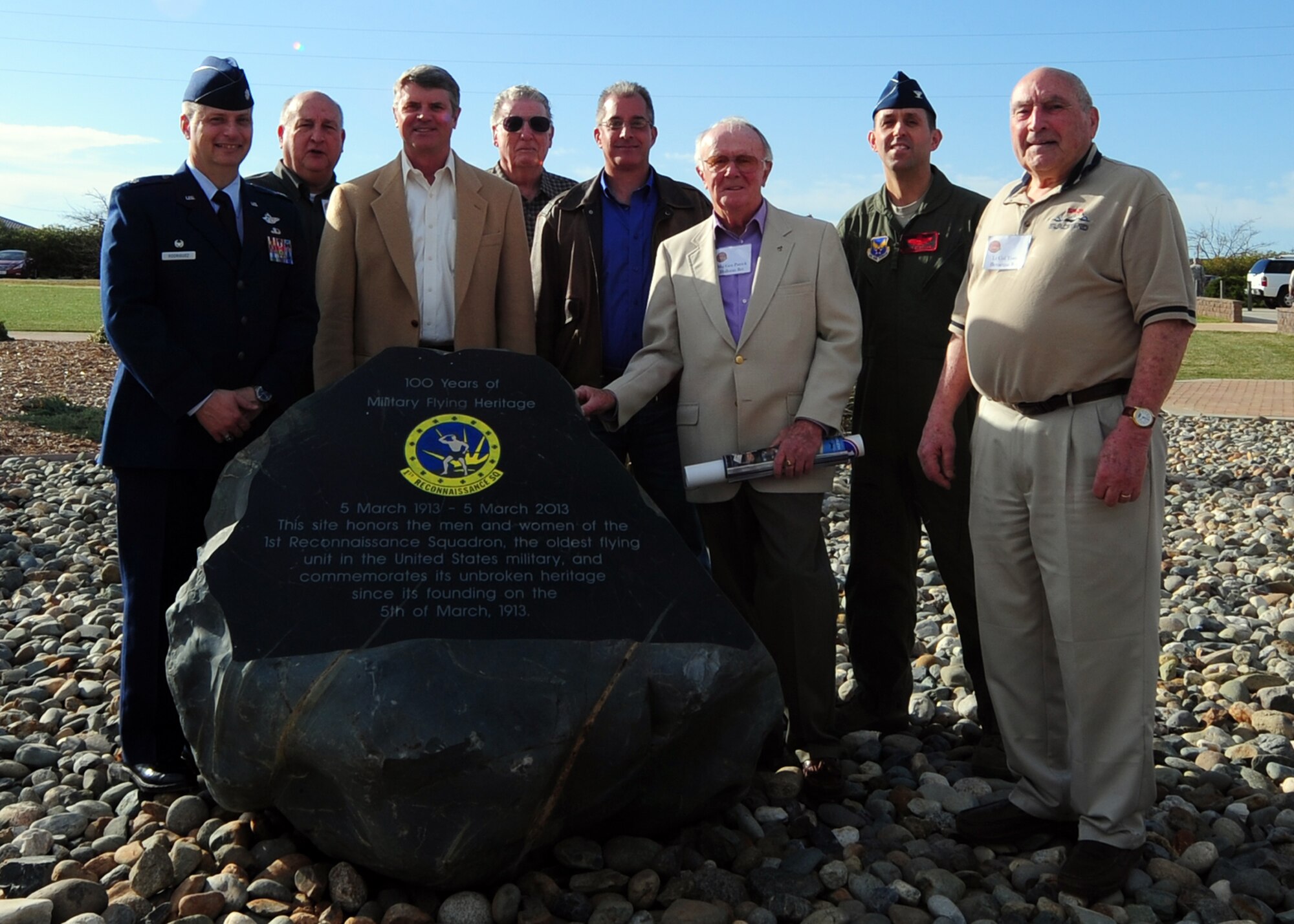 Former and current 1st Reconnaissance Squadron commanders, SR-71 Blackbird and U-2 “Dragon Lady” pilots pose with a plaque dedicated to the squadron during their centennial celebration March 8, 2013 at Beale Air Force Base, Calif. The plaque at Heritage Park rests in the shadow of an SR-71 Blackbird. (U.S. Air Force photo by Senior Airman Shawn Nickel/Released)