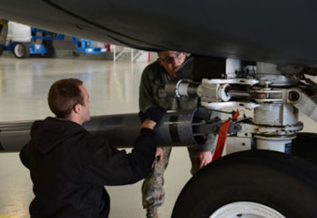 Master Sgt. Robert Ahern, a 137th Air Refueling Wing crew chief, left, and Airman 1st Class Mykal Short, a 507th Air Refueling Wing ISO Dock crew chief, hook up a tow bar and make sure the sheer pin is installed to be able to tow a KC-135 Stratotanker to the trim pad for engine runs. The 137th ARW, an Oklahoma Air National Guard unit, is a partner unit with the 507th ARW. The Airmen of both units work side-by-side to ensure the planes are well-maintained for mission capability. (Air Force photo by Kelly White)