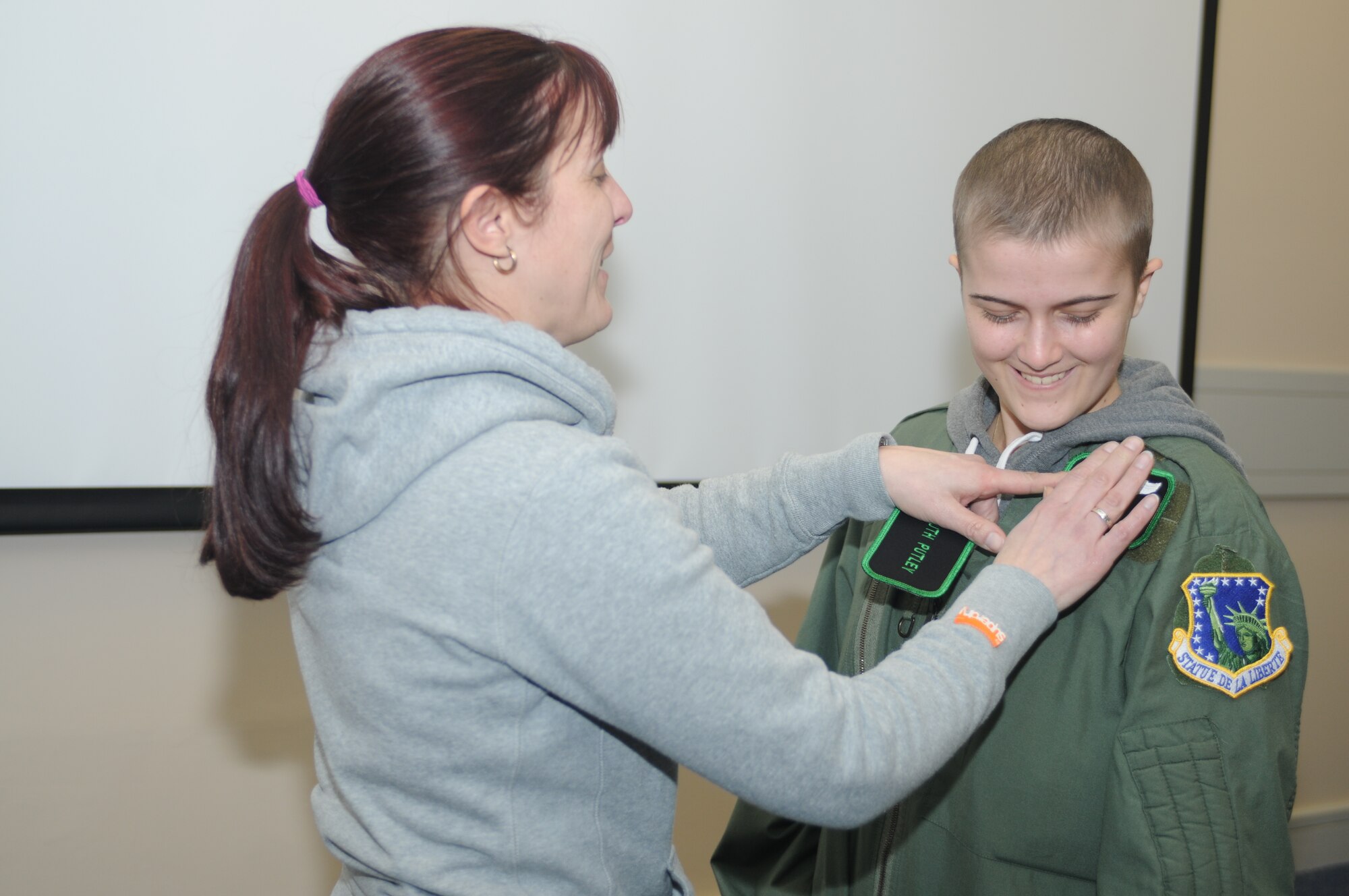ROYAL AIR FORCE LAKENHEATH, England – Sarah Lyon gives daughter Ruth Putley, 16, a 56th Rescue Squadron unit patch as a part of the last event for the “Pilot for a Day” program March 6, 2013. The “Pilot for a Day” event allows children suffering from life-threatening illnesses to come to RAF Lakenheath and experience what it is like to be a pilot. (U.S. Air Force photo by Airman 1st Class Dana J. Butler)