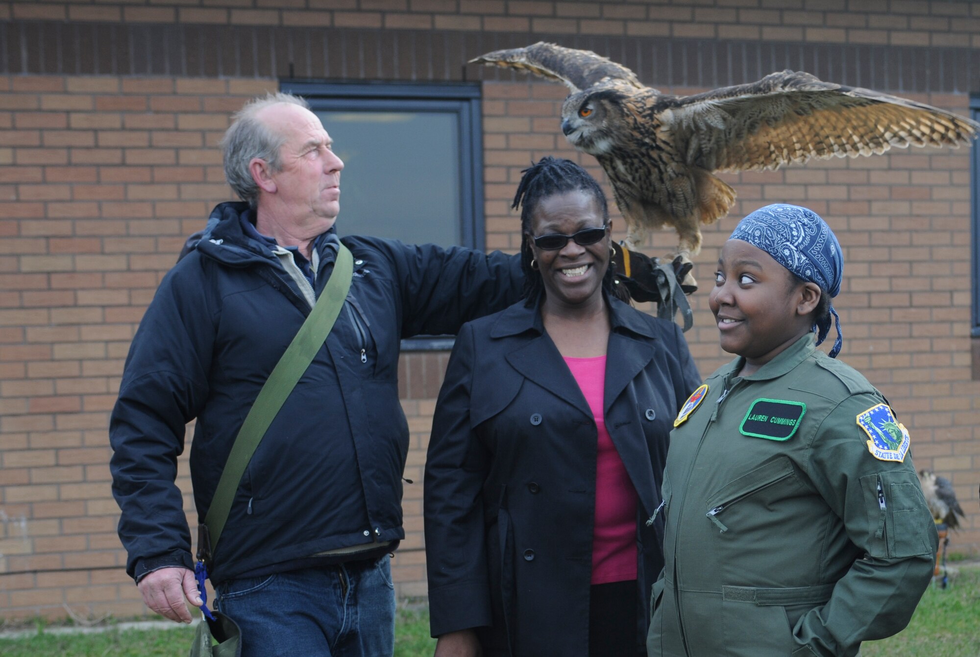 ROYAL AIR FORCE LAKENHEATH, England –Keith Mutton, Phoenix Bird Control falconer, holds Twinkle, a 26-year-old eagle owl, during a bird demonstration for Lauren Cummings, 12, and her mother Morvetta Cummings March 6, 2013. The demonstration was part of the “Pilot for a Day” event which allows children suffering from life-threatening illnesses to come to RAF Lakenheath and experience what it is like to be a pilot.  (U.S. Air Force photo by Airman 1st Class Dana J. Butler)
