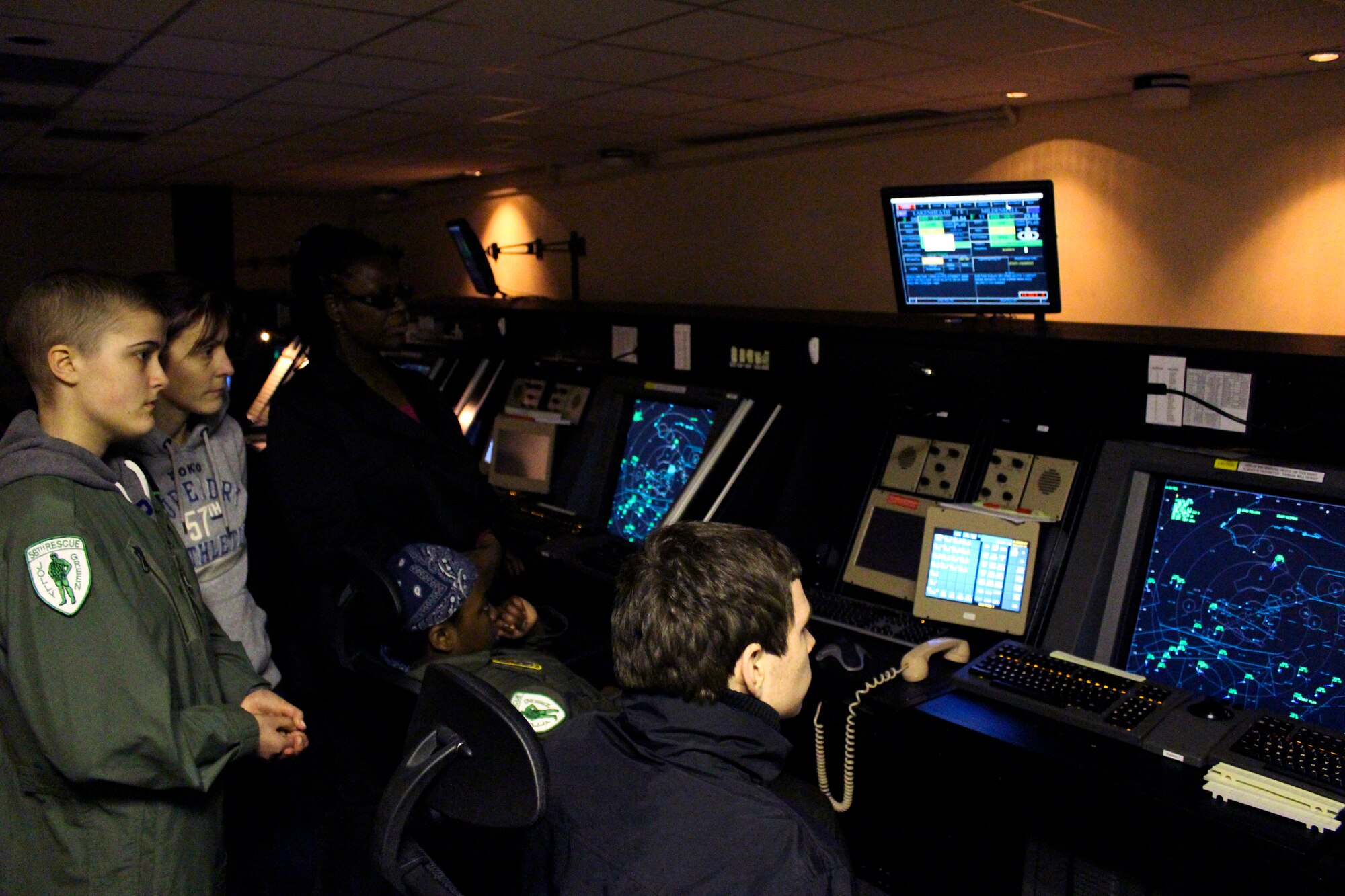 ROYAL AIR FORCE LAKENHEATH, England – Ruth Putley (standing), 16, Lauren Cummings (sitting), 12, and their mothers examine radar displays at Radar Approach Control, during a “Pilot for a Day” event March 6, 2013. The program allows children with a life-threatening illness or condition to come to RAF Lakenheath and experience what it’s like to be a pilot. (U.S Air Force photo by 2nd Lt. Keenan Kunst)