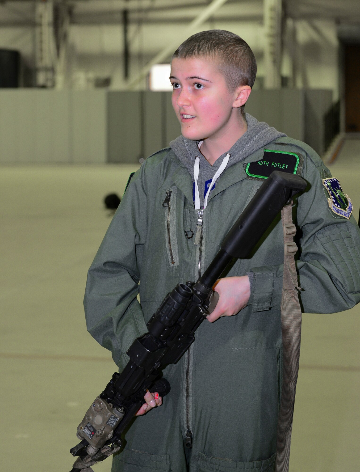 ROYAL AIR FORCE LAKENHEATH, England – Ruth Putley, 16, carries an M4 Carbine during the “Pilot for a Day” event March 6, 2013. During the event, two local children received special-made flight suits, a flight in an F-15 simulator, an interactive squadron tour, a birds of prey demonstration and an up-close viewing of an F-15C Eagle and an HH-60G Pave Hawk. (U.S. Air Force photo by Staff Sgt. Stephanie Mancha)