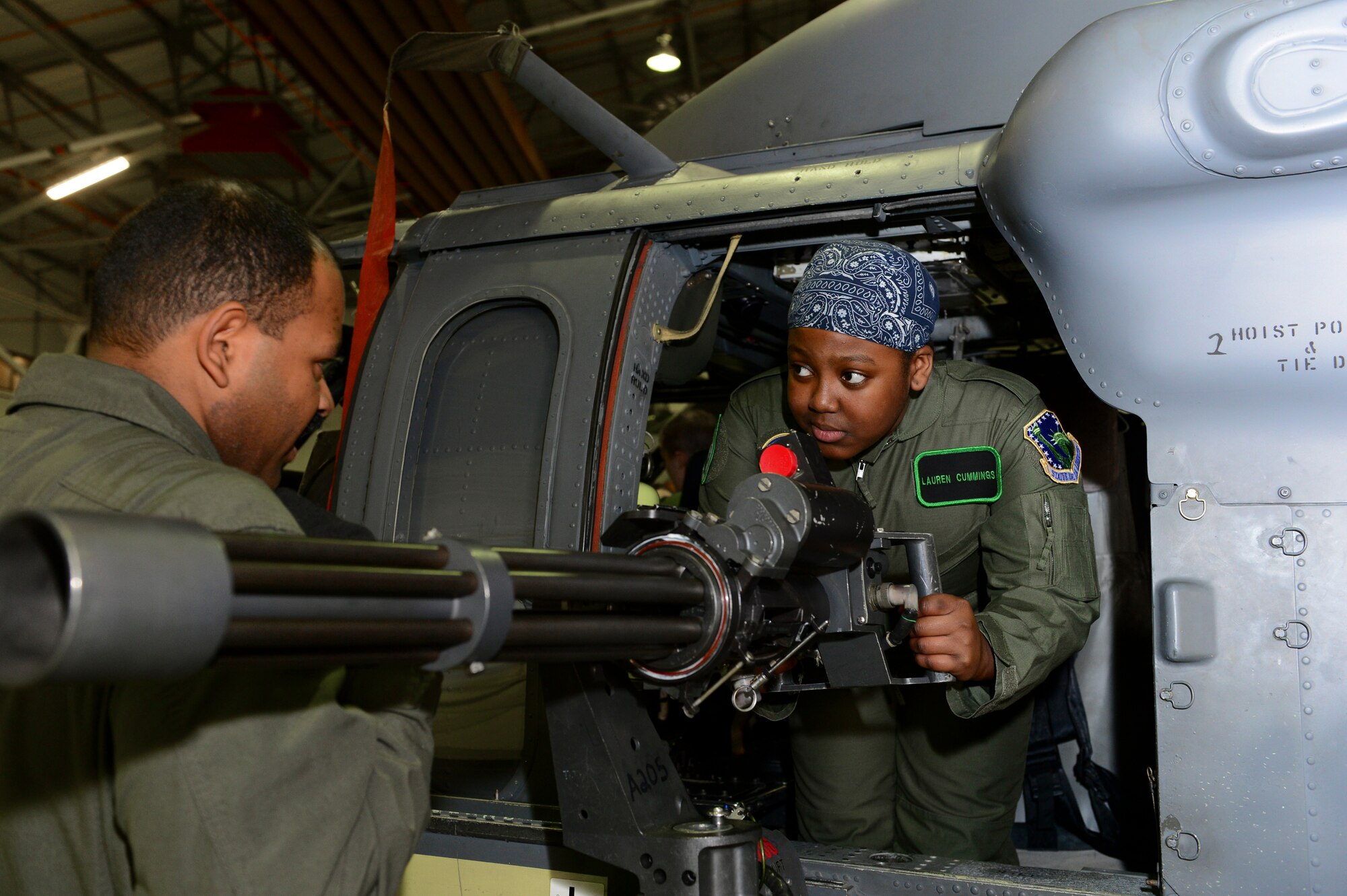 ROYAL AIR FORCE LAKENHEATH, England – Staff Sgt. Chauncey Padilla, 56th Rescue Squadron flight engineer, shows Lauren Cummings, 12, a GAU-2C mini-gun on an HH-60G Pave Hawk during a “Pilot for the Day” event March 6, 2013. The program allows children with a life-threatening illness or conditions to come to RAF Lakenheath and experience what it’s like to be a pilot. (U.S. Air Force photo by Staff Sgt. Stephanie Mancha)