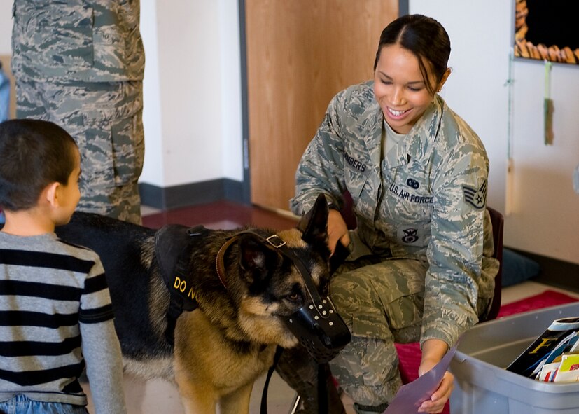 U.S. Air Force Staff Sgt. Kathy Chambers, 7th Security Forces Squadron, shows Bartja, a 7th SFS military working dog, a letter written by a kindergartener thanking them for their service March 7, 2013, in Abilene, Texas. During the visit, children from Martinez Elementary School had the opportunity to interact with Airmen from security forces, maintenance and public affairs. The Airmen talked to the children about their jobs and why they joined the Air Force. At the end of the visit, students read handwritten letters to the Airmen. (U.S. Air Force photo by Airman 1st Class Damon Kasberg/ Released)