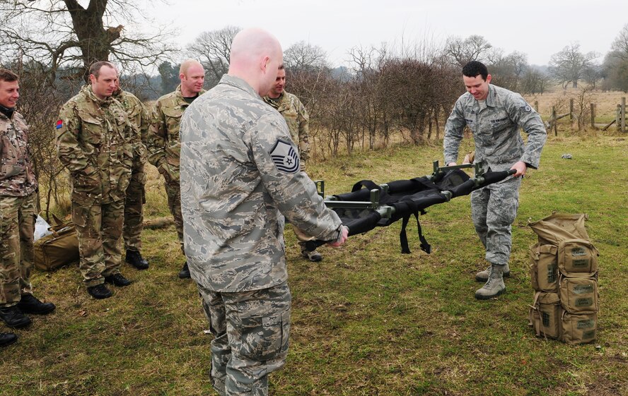 Master Sgt. Scott Piper, 352nd Special Operations Support Squadron Medical Element flight chief from Las Vegas, and Staff Sgt. Tyler Hamilton, 352nd SOSS independent duty medical technician from Choctaw, Okla., demonstrate to British Army members how quickly a Talon litter can be unfolded and made ready to carry a patient March 6, 2013, at Stanford Training Area, near Thetford, England. British Army soldiers from 19 Regiment Royal Artillery in Tidworth, Wiltshire, and 3 Battalion The Rifles, from Edinburgh, Scotland, spent two days with the  U.S. Air Force members learning different medical techniques which could be used in a deployed environment to help save lives of people from many different nations. (U.S. Air Force photo by Karen Abeyasekere/Released)