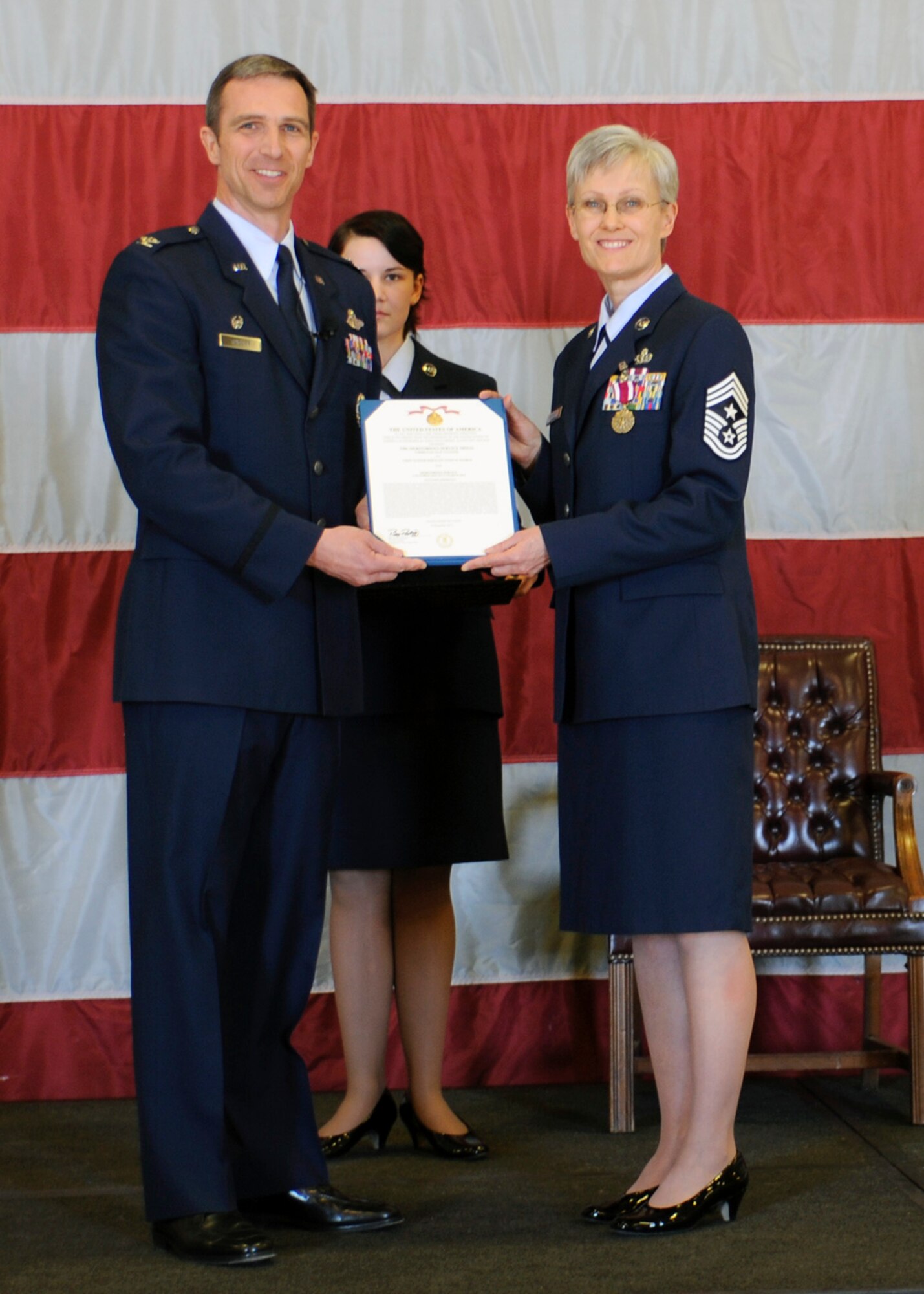 Chief Master Sgt. Cindy George, 419th Fighter Wing command chief, receives a Meritorious Service Medal from 419th Commander Col. Bryan Radliff during the chief’s retirement ceremony here Sunday. Chief George served as the wing’s command chief for three years. (U.S. Air Force photo/Staff Sgt. Heather Skinkle)