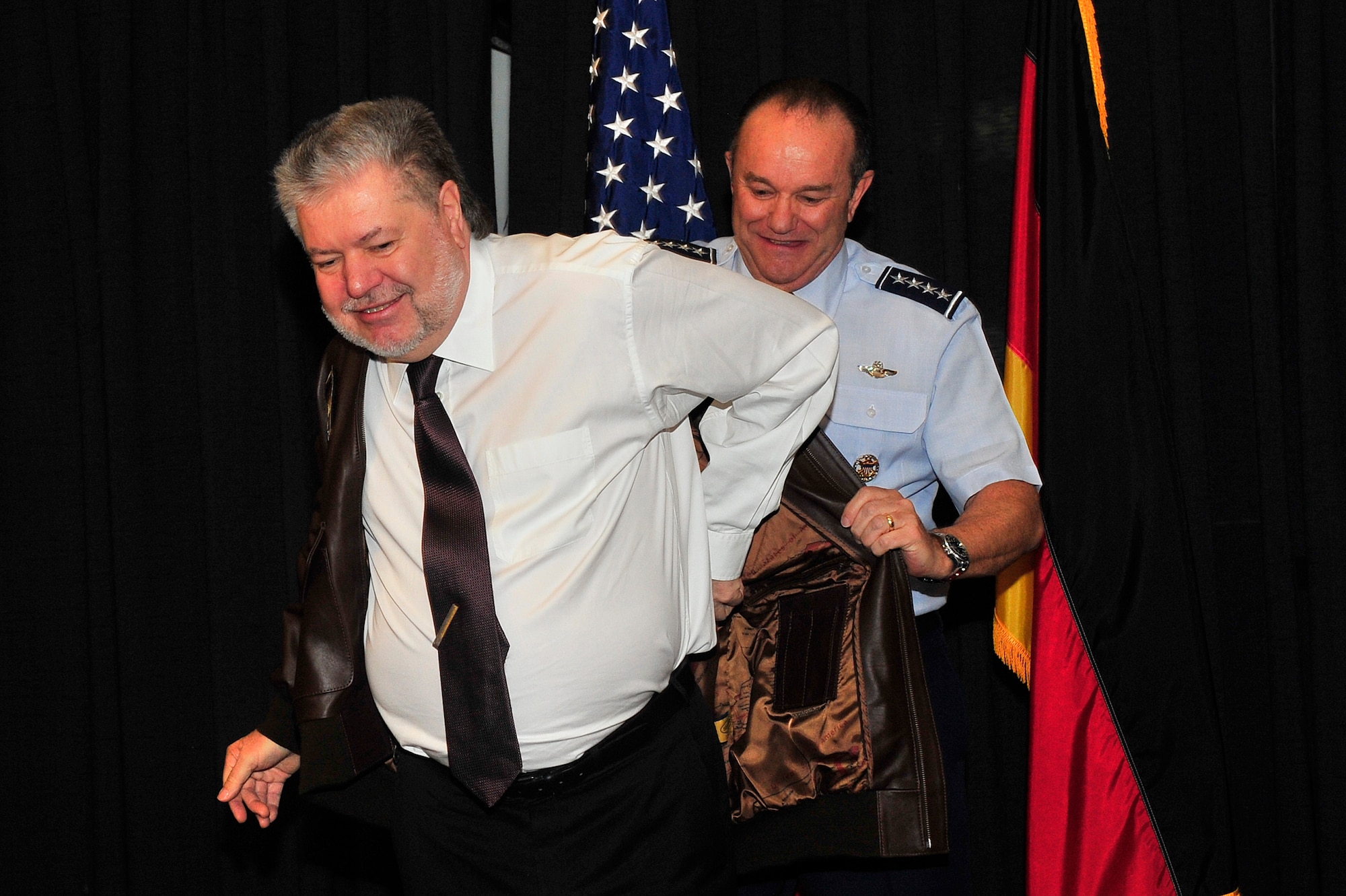 Gen. Philip M. Breedlove, United States Air Forces in Europe and Air Forces Africa commander, assists former Minister President Kurt Beck with putting his flight jacket on during Beck’s U.S. Air Forces in Europe Medal of Distinction ceremony on Ramstein Air Base, Germany, March 8, 2013.  The USAFE Medal of Distinction is awarded to non-U.S. citizens in recognition of extraordinary service, achievements, or support to the accomplishment of the mission of USAFE. (U.S. Air Force photo/Senior Airman Aaron-Forrest Wainwright)