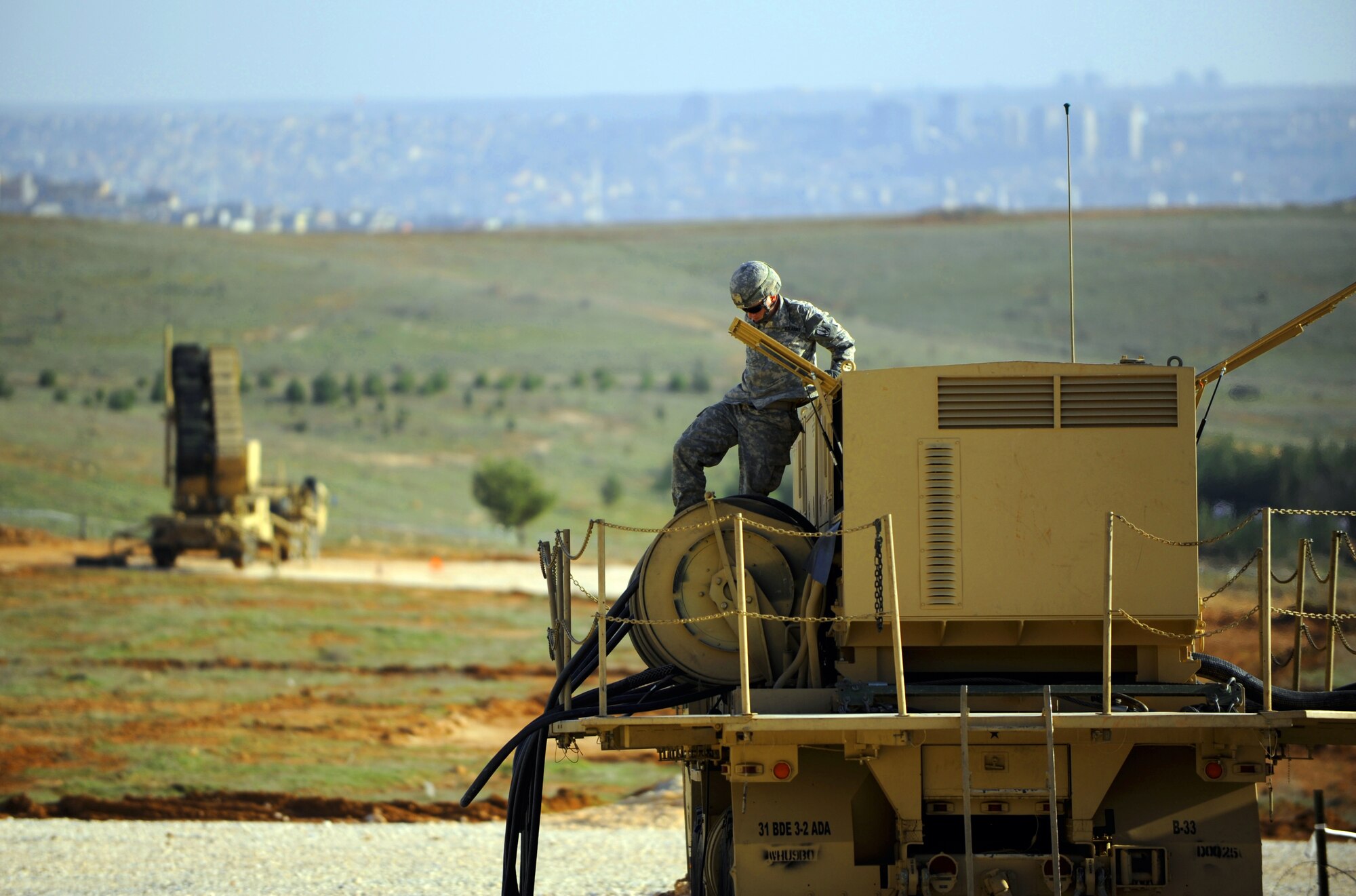 A U.S. Army soldier from Fort Sill, Okla. climbs down from an Electrical Power Plant after refueling it Feb. 28, 2013, near Gaziantep, Turkey. EPPs are used to power the Patriot battery site’s equipment. (U.S. Air Force photo by Senior Airman Daniel Phelps/Released)