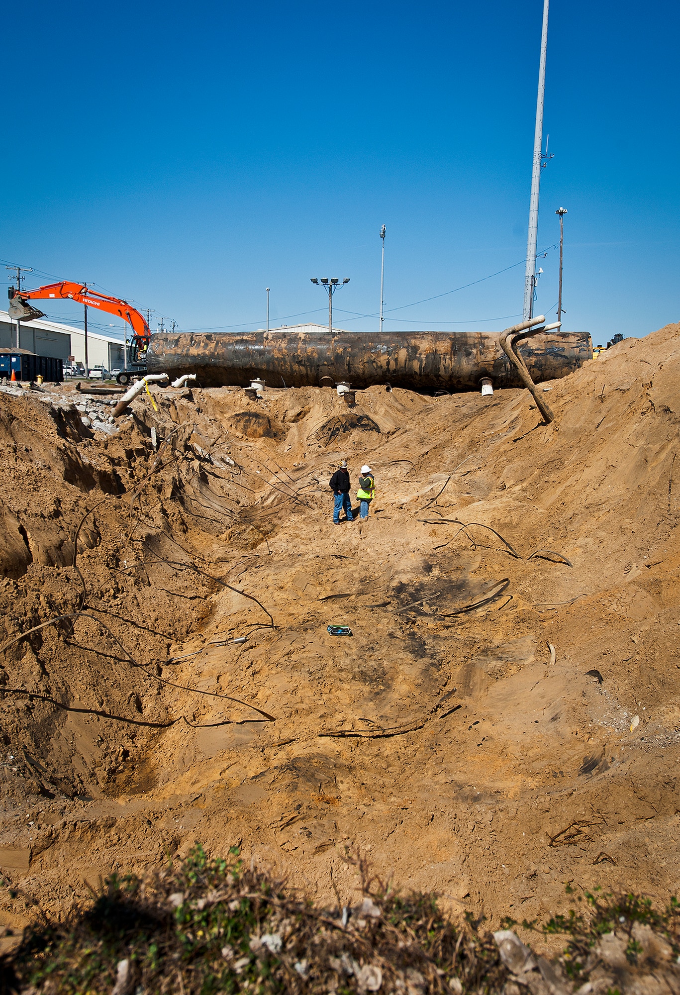 Workers stand in the hole left after removing two of the four 50,000 gallon underground fuel storage tank systems at the 33rd Fighter Wing March 11 at Eglin Air Force Base, Fla.  The tank systems have been in place since 1959 and formerly used to refuel 33rd FW aircraft until recently.  The new fuel storage system is already in place and increases the wing's capacity to more than a million gallons of JP-8 for the F-35s.  (U.S. Air Force photo/Samuel King Jr.)