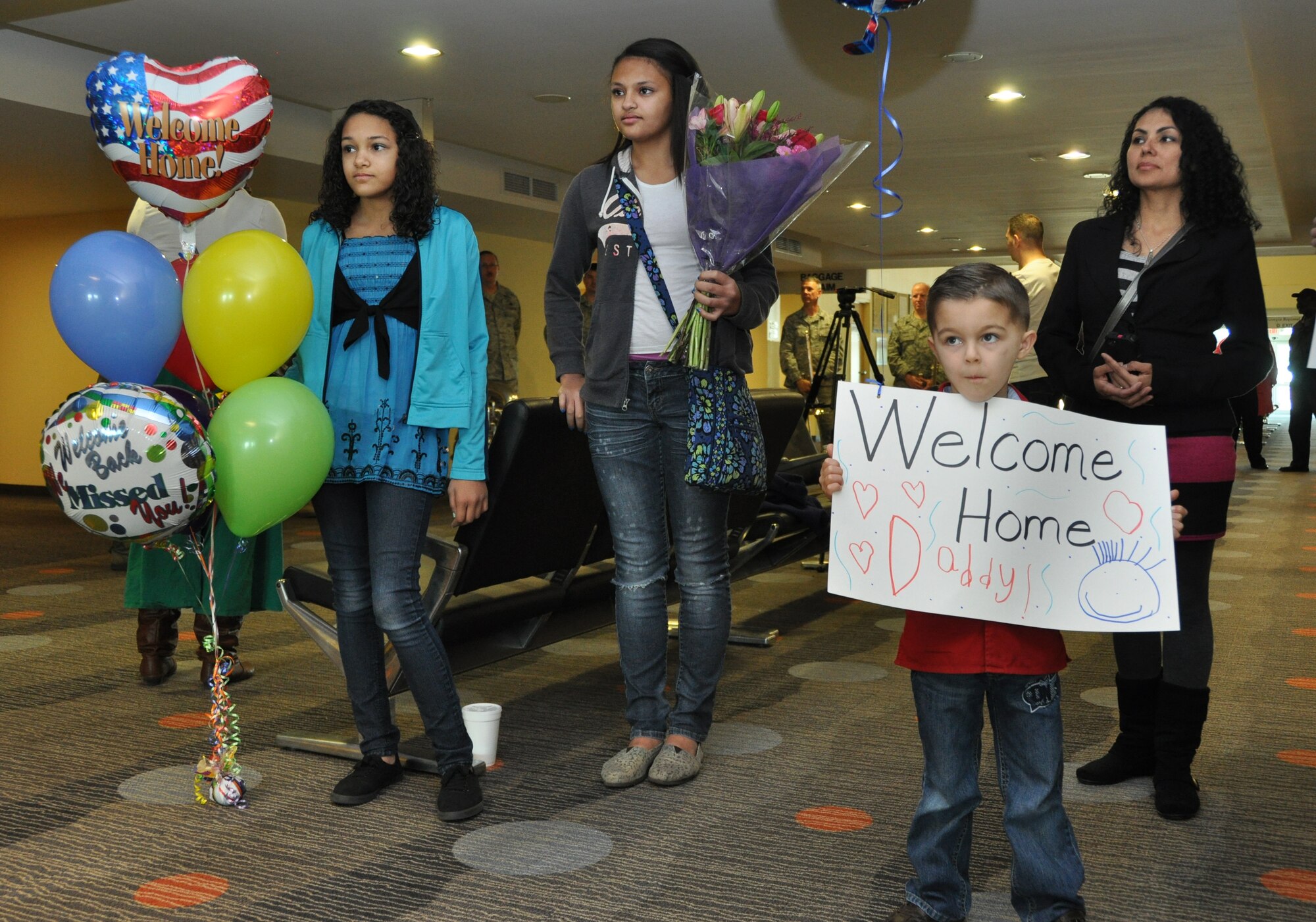 Family members eagerly await the return of their loved ones at the Macon Regional Airport March 8. Six members of the Band of the Air Force Reserve completed a nearly 4-month deployment to Southwest Asia. Their return signaled the final overseas deployment for the band, which is slated for deactivation at the end of September 2013. (U.S. Air Force photo/Philip Rhodes)