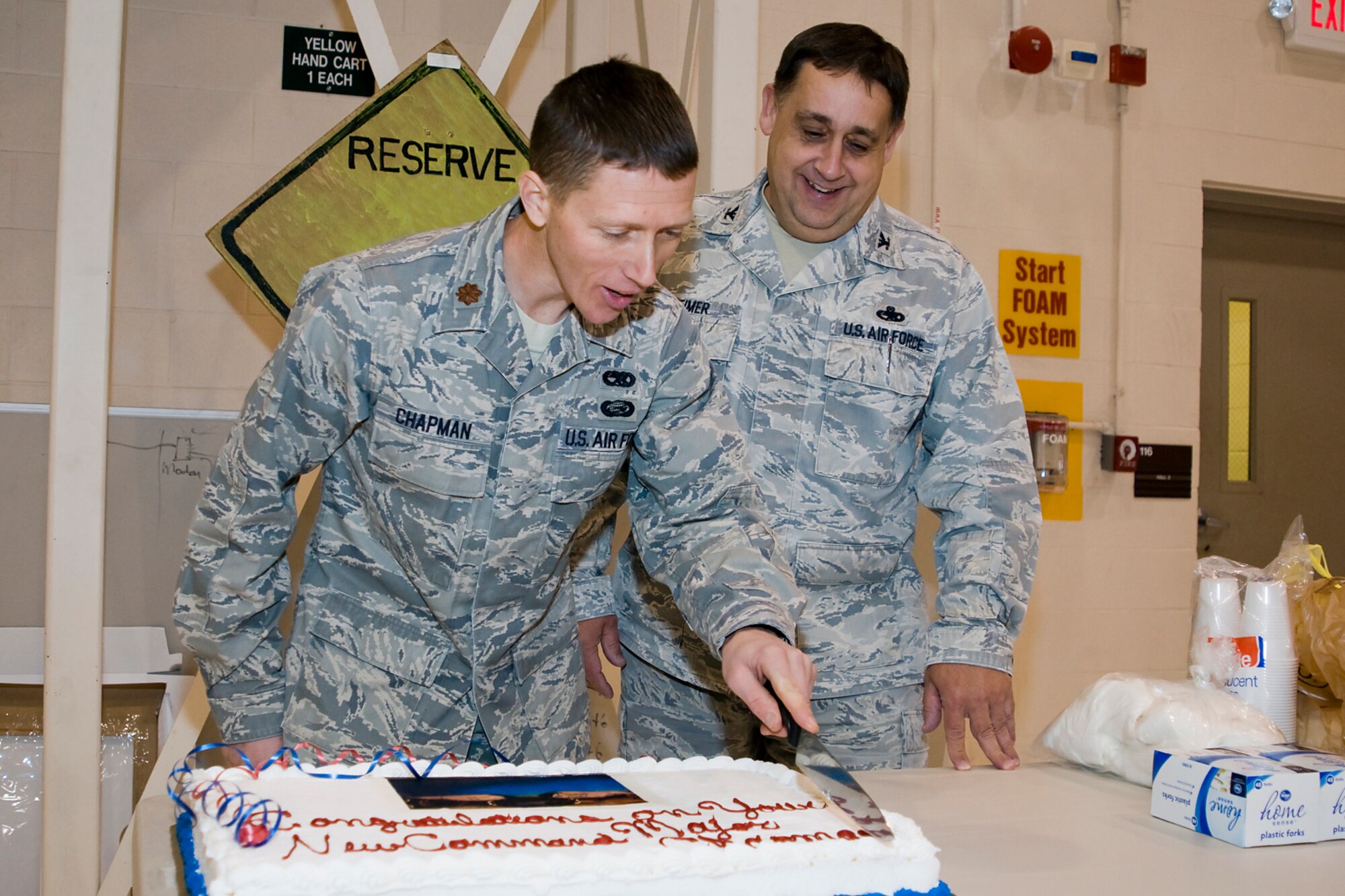 GRISSOM AIR RESERVE BASE, Ind. -- Maj. William Chapman cuts his celebration cake after taking command of the 434th Maintenance Squadron as Col. Paul Weimer, 434th Maintenance Group commander, watches. Prior to his assumption of command, Chapman was a 434th Aircraft Maintenance Squadron operations officer. (U.S. Air Force photo/Staff Sgt. Ben Mota)