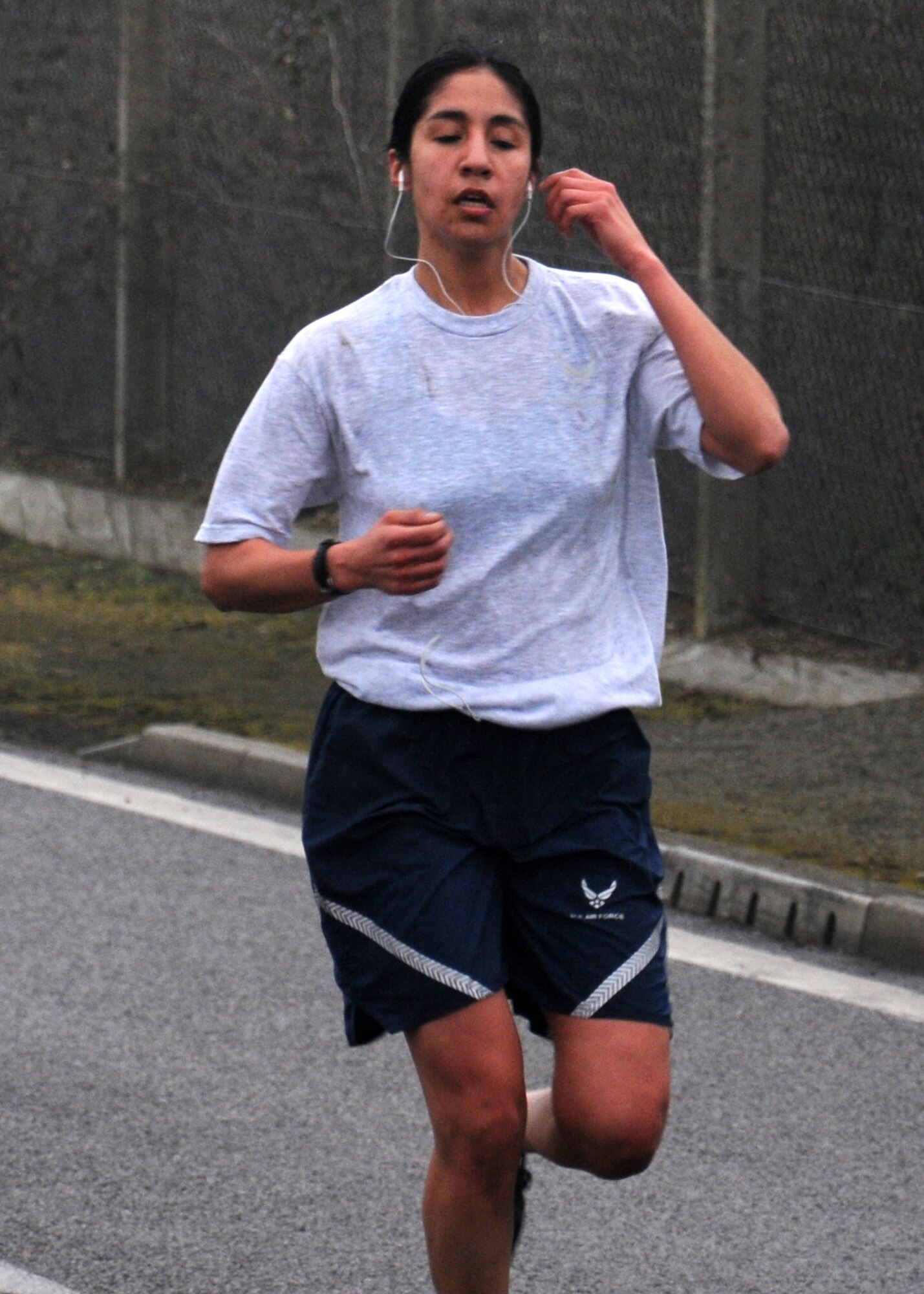 Staff Sgt. Jessica Garcia, 100th Security Forces Squadron Visitor Control Center NCO in charge from Apple Valley, Minn., is the first female to cross the finish line at a wing run March 8, 2013, on Perimeter Road near the Hardstand Fitness Center on RAF Mildenhall, England. Garcia completed the 5K run with a time of 19.22. The run was the last one of the year to begin at 3p.m.; due to the longer daylight hours, next month’s run will begin at 3.30p.m. (U.S. Air Force photo by Gina Randall/Released)