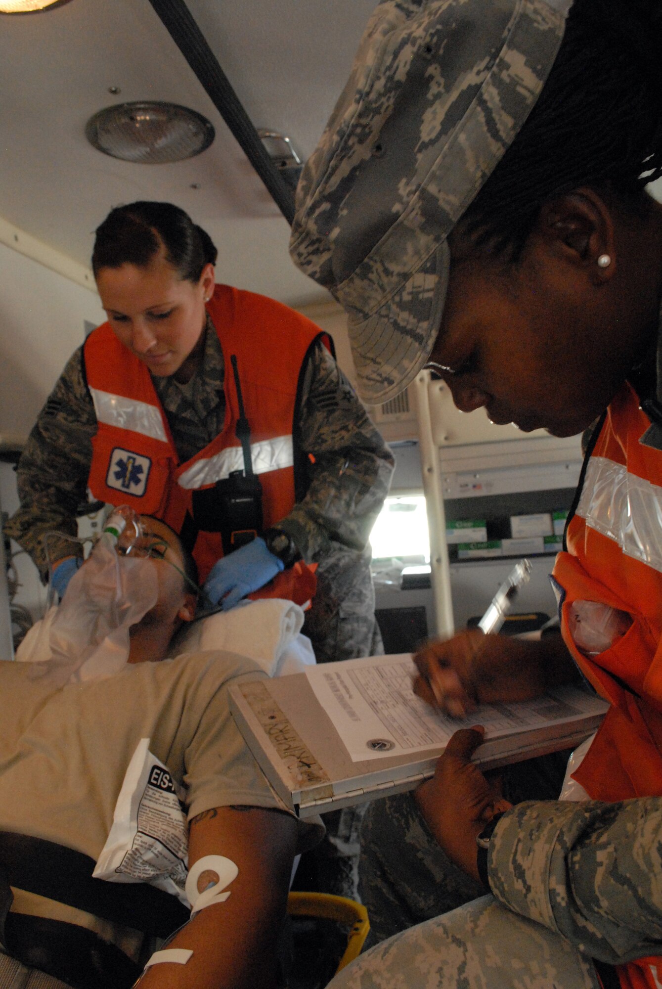 Senior Airman Sonni Hamill prepares a patient for transport to the base medical clinic while Senior Airman Diana Ceus records the patient's personal information, Mar. 8. The 379th Expeditionary Medical Group serves all the emergency and transient medical needs for the 379th Air Expeditionary Wing and tenant units. (U.S. Air Force photo/Master Sgt. Christian Michael)