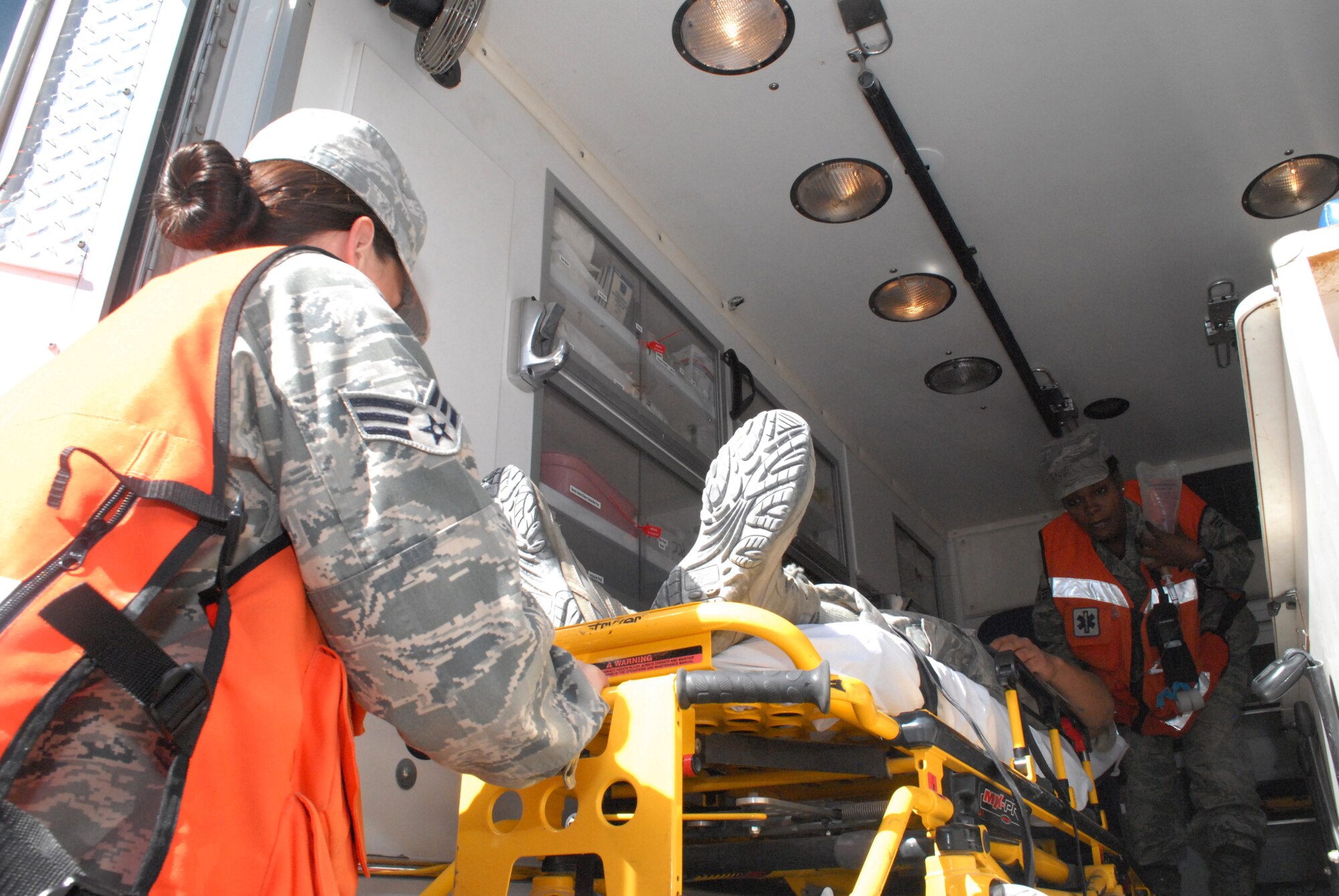 Senior Airmen Sonni Hamill and Diana Ceus, medical technicians, prepare to transfer a patient from the ambulance to the base medical clinic, Mar. 8. The 379th Expeditionary Medical Group serves all the emergency and transient medical needs for the 379th Air Expeditionary Wing and tenant units. (U.S. Air Force photo/Master Sgt. Christian Michael)
