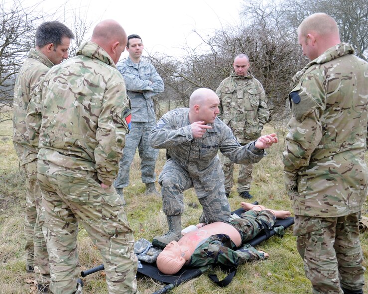 Master Sgt. Scott Piper, center, 352nd Special Operations Support Squadron Medical Element flight chief from Las Vegas, briefs members of the British Army March 6, 2013, at Stanford Training Area, near Thetford, England. Piper helped inform the U.K. military members of the U.S. practices in recovering an injured person in the field. The procedure is to deal with any obvious wounds, look for a fatal wound, stop the bleeding, then move the patient to a safe place then bandage the wound. (U.S. Air Force photo by Gina Randall/Released)