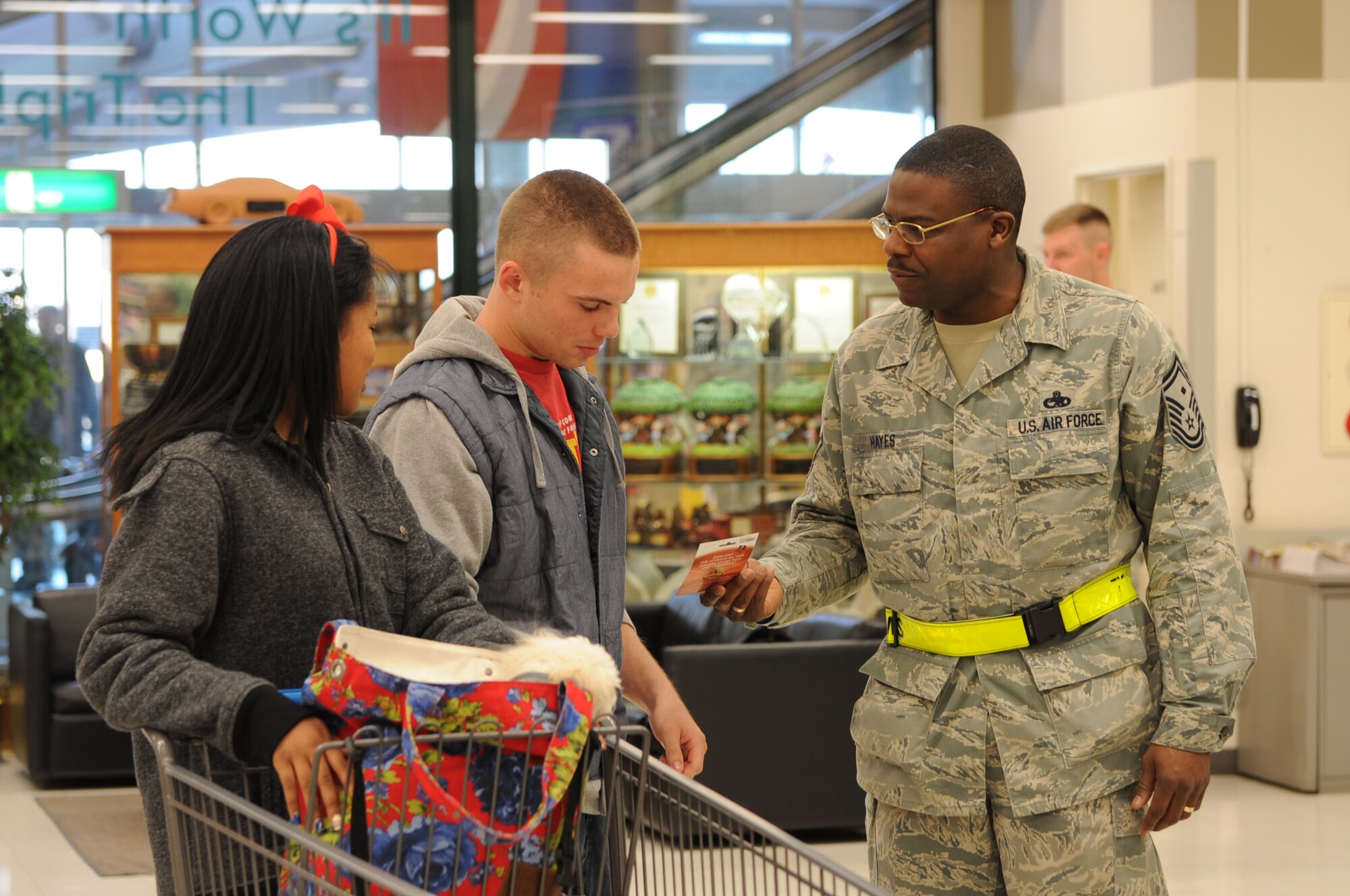 YOKOTA AIR BASE, Japan -- Right, Senior Master Sgt. Henry Hayes, 730th Air Mobility Squadron first sergeant, hands a commissary gift card to Airman 1st Class Craig Deacon, 374th Civil Engineer Squadron fire protection member, and his wife Jessica Feb. 28, 2013, at Yokota Air Base, Japan. The First Sergeants’ Council delivers random acts of kindness throughout the year to service members at Yokota. (U.S. Air Force photo by Airman 1st Class Desiree Economides)
