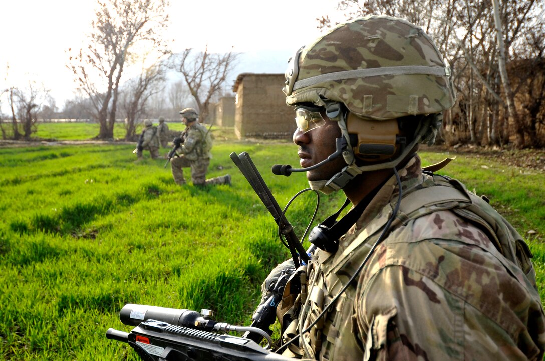 Senior Airman Robert Chukwurah, 755th Expeditionary Security Forces Squadron Reaper Team 5 fire team member, takes a knee to provide security while his team leader conducts a conversation near Bagram Airfield, Afghanistan, March 9, 2013.  Reaper Team 5 conducts patrols near Bagram Airfield to counter improvised explosive devices and indirect fire attacks as well as to engage locals’ support in protecting the base.  (U.S. Air Force photo/Capt. Erika Yepsen)