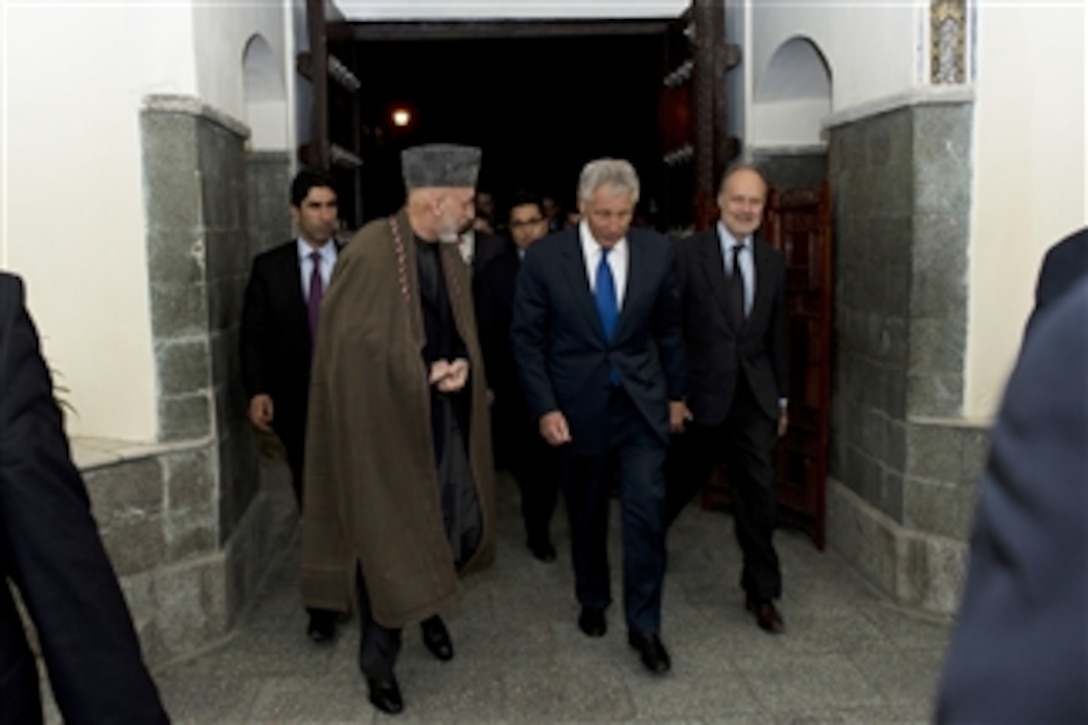 Secretary of Defense Chuck Hagel, center, walks with President of Afghanistan Hamid Karzai, left, in Kabul, Afghanistan, on March 10, 2013.  Hagel is in Afghanistan on his first trip as secretary of defense to visit U.S. troops, NATO leaders, and Afghan counterparts.  