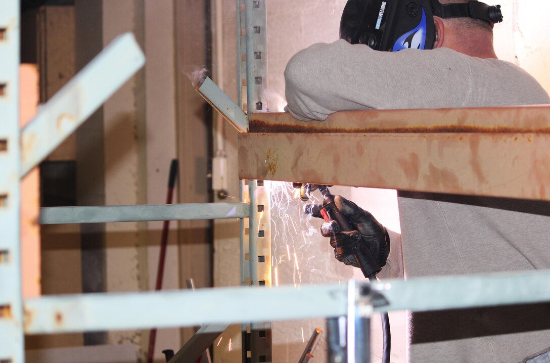 A servicemember with 2nd Supply Battalion, 2nd Marine Logistics Group welds together a shelving unit in the storage area at the USO in Jacksonville, N.C., during a remodeling effort launched in January. Volunteers from the unit spent several weeks updating the facility’s food-storage area to accommodate  more than 6,000 pounds of supplies donated during the battalion’s food drive.  