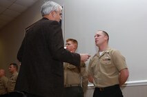 John Falkenbury, the USO of North Carolina president, presents an award to a sailor with Medical Logistics Company, 2nd Supply Battalion, 2nd Marine Logistics Group at the USO in Jacksonville, N.C., March 7, 2013. A group of Marines and sailors received awards for volunteering to help remodel the buildings storage facilities for nonperishable food items. 