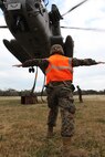 : A landing support specialist guides a CH-53E Super Stallion as it lifts simulated cargo during a field exercise conducted by Combat Logistics Battalion 6, 2nd Marine Logistics Group aboard Camp Lejeune, N.C., Feb. 28, 2013. The battalion used the operation as a training aid for vehicle operators, who may be called upon to conduct helicopter support missions during their upcoming deployment to Afghanistan. 