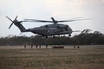 Marines from Landing Support Company, Combat Logistics Regiment 27 conduct an exercise helicopter support mission at landing zone Bluebird aboard Camp Lejeune, N.C., Feb. 28, 2013. A helicopter support team consists of eight Marines whose job is to safely attach various pieces of gear and equipment to a helicopter. An important step in the process is grounding the dangling hooks to ensure the static charge is non-lethal.
