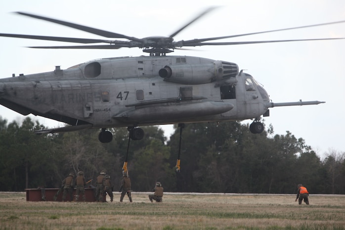 Marines from Landing Support Company, Combat Logistics Regiment 27 conducts a helicopter support team training exercise at Landing Zone Bluebird aboard Camp Lejeune, N.C., Feb. 28, 2013. A HST consists of eight Marines whose job is to safely attach various pieces of gear and equipment to a helicopter. An important step in the process is grounding the dangling hooks to ensure the static charge is non-lethal.