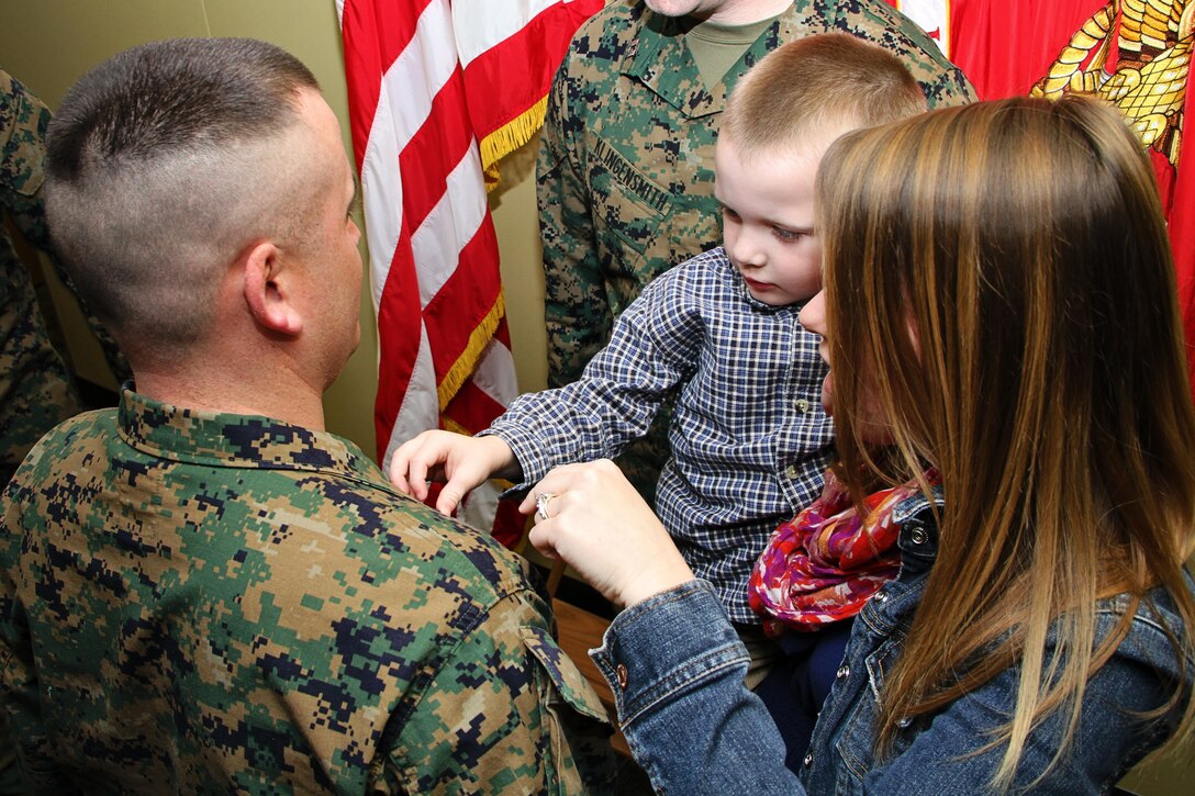 Jeremiah Junior, the son of GySgt Jeremiah Gibbs, pins a new set of
chevrons on his father's collar during a promotion ceremony at the Robert A.
Young Federal building in St. Louis, Mar 1. Gibbs is the Staff
Non-Commissioned Officer In Charge at Recruiting Sub-Station West County.
