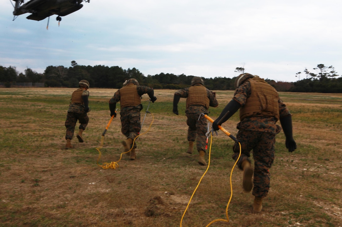 A crew of landing support specialists race towards a CH-53E Super Stallion during a joint training exercise with motor transportation operators with Combat Logistic Battalion 6, 2nd Marine Logistics Group aboard Camp Lejeune, Feb. 28, 2013. Thirty-one members of the battalion observed as the landing support specialists demonstrated techniques for guiding helicopters into desired landing sites. 