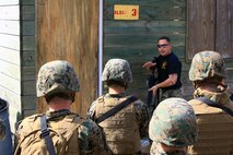 Sgt. Jacob W. Dofner, a McClelland, Iowa, native and an instructor with Battle Skills Training School, 2nd Marine Logistics Group, gives a demonstration on how to approach a dangerous area aboard Camp Lejeune, N.C., Feb. 27, 2013, during a training exercise. Marines with Engineer Operation Company, Marine Wing Support Squadron 274, out of Marine Corps Air Station Cherry Point, N.C., practiced room clearing techniques after hours of classroom instruction classroom instruction from instructors. 