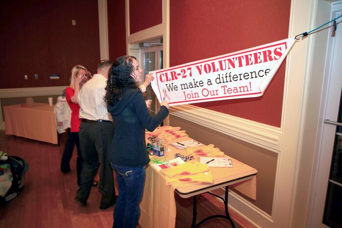 Nakyshia R. Leger, a volunteer with Combat Logistics Regiment 27, 2nd Marine Logistics Group, puts up a sign before an event at Marston Pavilion aboard Camp Lejeune, N.C., Feb. 27, 2013. Volunteers set up signs, organized tables and helped the family readiness officer prepare for the evening’s festivities as Col. Gary F. Keim, the commanding officer of the regiment, socialized with servicemembers and their families. 