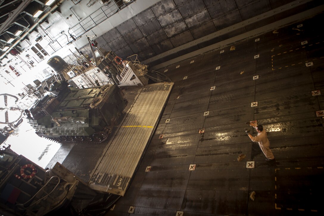 A Marine with Battalion Landing Team 3/5, 15th Marine Expeditionary Unit, directs an amphibious assault vehicle off a landing craft air cushion aboard the USS Green Bay, March 9. The 15th MEU is deployed as part of the Peleliu Amphibious Ready Group as a U.S. Central Command theater reserve force, providing support for maritime security operations and theater security cooperation efforts in the U.S. 5th Fleet area of responsibility. (U.S. Marine Corps photo by Cpl. Bobby J. Gonzalez/Released)